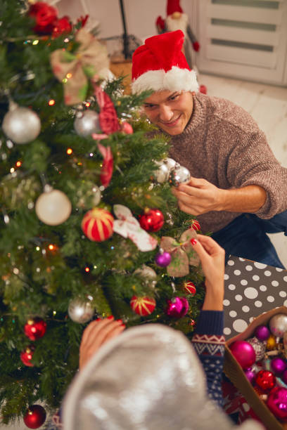 istock Happy couple decorating tree for New Year's / Christmas eve. 1065462268