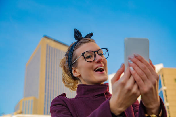 istock Cute smiley girl using cellphone in urban surroundings. 1065462378