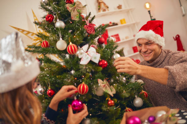 istock Happy couple decorating tree for New Year's / Christmas eve. 1065463012