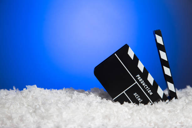 Frozen film clapper / movie clapperboard on blue background with copy space.