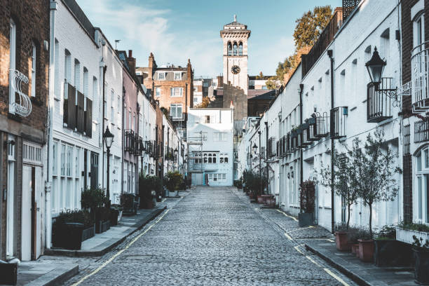 Exclusive mews in London Exclusive mews with small houses on the end tower of church kensington and chelsea photos stock pictures, royalty-free photos & images
