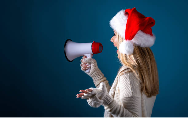 istock Young woman with santa hat holding a megaphone 1065479922