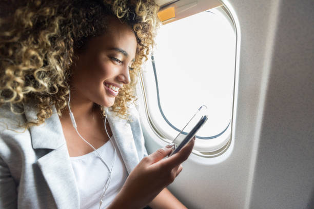 istock A smiling woman sits next to an open plane window and smiles 1065483384