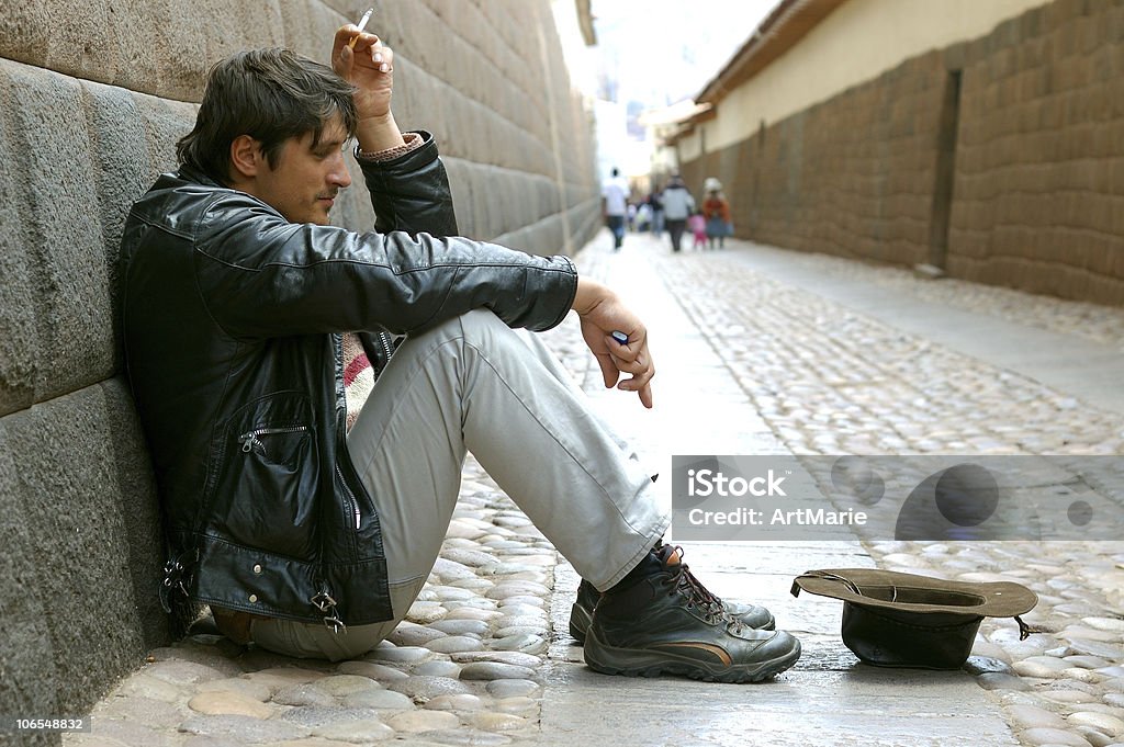 Mendicidad hombre sentado cerca de Inca pared, Perú, Cuzco - Foto de stock de Sin techo libre de derechos