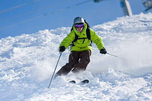 Individual with green anorak skiing off-piste Young man on skis out of slopes. Off-piste skiing la plagne photos stock pictures, royalty-free photos & images