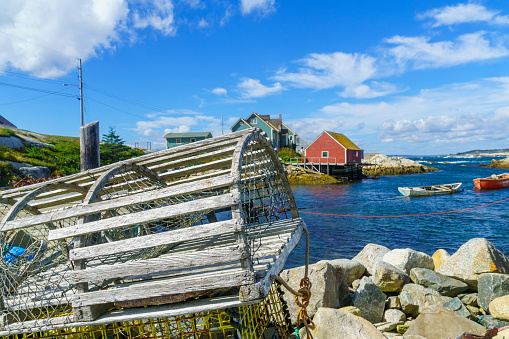 View of lobster traps, boats and houses, in the fishing village Peggys Cove, Nova Scotia, Canada