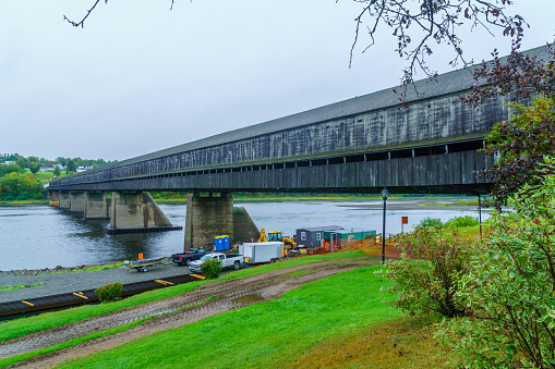 Hartland, Canada - September 26, 2018: View of the longest covered bridge in the world, with road workers, in Hartland, New Brunswick, Canada