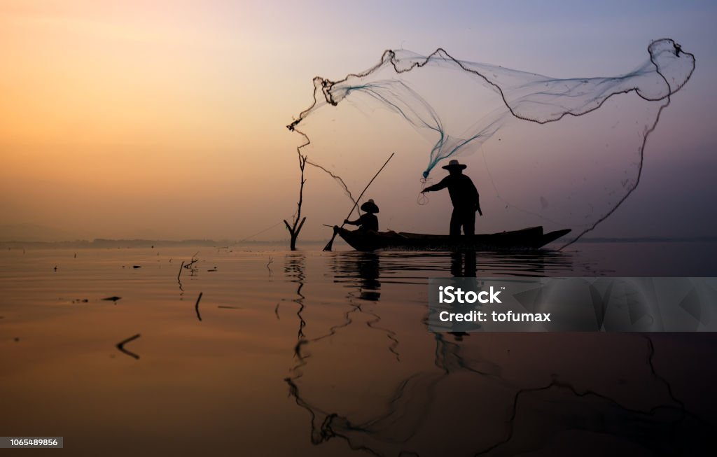 Asian Fishermen Throwing Fishing Net During Twilight On Wooden Boat At The  Lake Concept Fishermans Lifestyle In Countryside Lopburi Thailand Asia  Stock Photo - Download Image Now - iStock, fishnet fishing