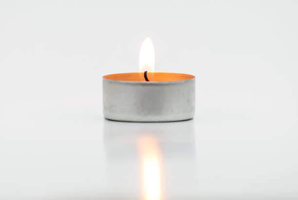 Burning paraffin candles, tealight, lies on a white background with a clipping path.