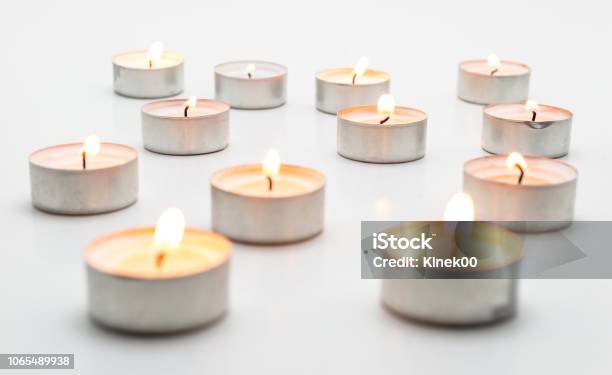 Burning Paraffin Candles Tealight Lies On A White Background Stock Photo - Download Image Now
