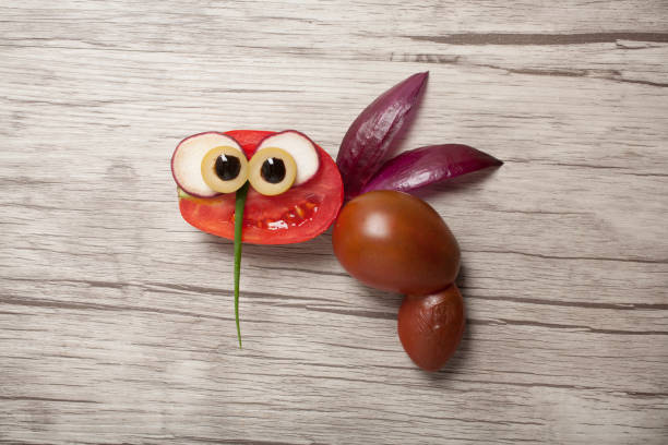Bee made with tomato, onion, radish and olive. Shot on wooden background.