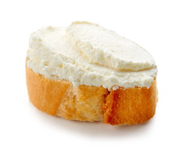 istock Fresh cream cheese on bread isolated on white background 1065493242