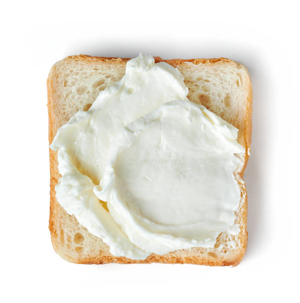 istock Fresh cream cheese on bread isolated on white background 1065493314