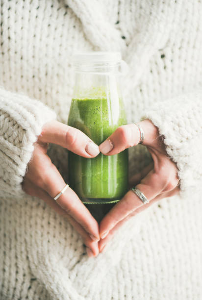 istock Healthy smoothie or juice in bottle in woman's hands 1065494986