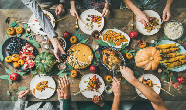 istock Friends feasting at Thanksgiving Day table with turkey, top view 1065495342