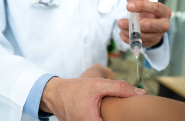 Doctor using syringe to give in jection to patient