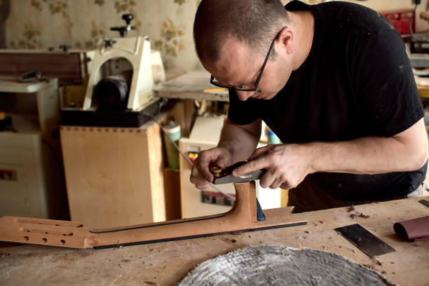 istock luthier is working on the neck of a classical guitar. 1065506632