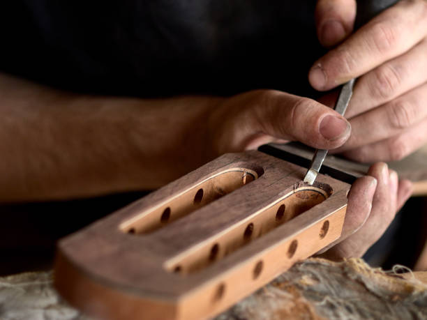 istock luthier modifies the head of a classical guitar. 1065506678