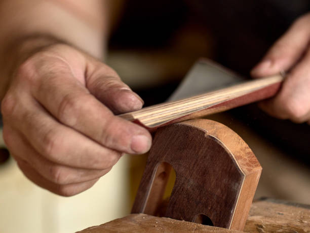 istock luthier modifies the head of a classical guitar. 1065506702