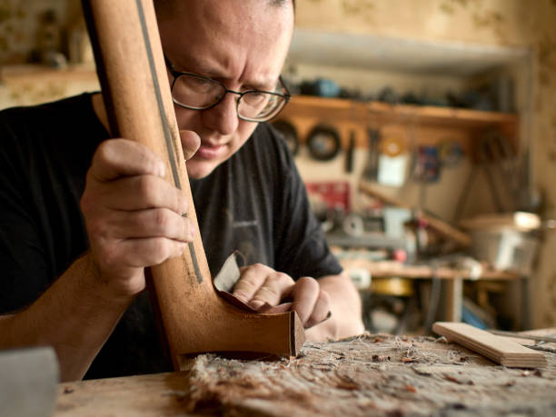istock luthier is working on the neck of a classical guitar. 1065506720