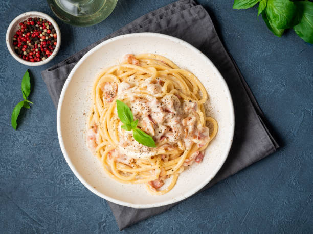 istock Carbonara pasta. Spaghetti with pancetta, egg, parmesan cheese and cream sauce. Traditional italian cuisine. Top view 1065506948