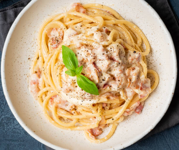 istock Carbonara pasta. Spaghetti with pancetta, egg, parmesan cheese and cream sauce. Traditional italian cuisine. Top view, close up 1065507004