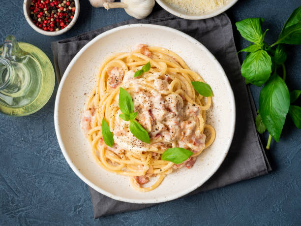 istock Carbonara pasta. Spaghetti with pancetta, egg, parmesan cheese and cream sauce. Traditional italian cuisine. Top view 1065507032