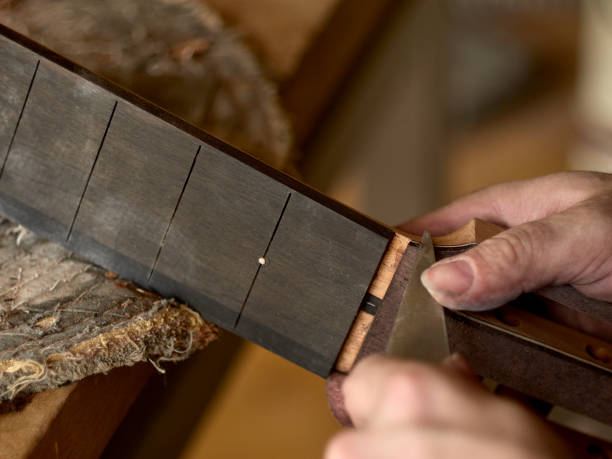 istock luthier is working on the neck of a classical guitar. 1065508330