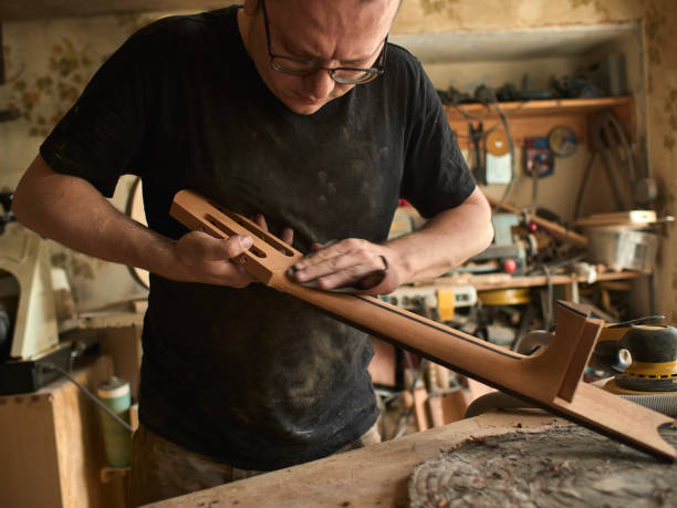 istock luthier is working on the neck of a classical guitar. 1065508334