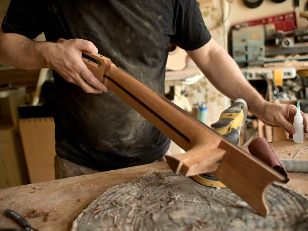 istock luthier is working on the neck of a classical guitar. 1065508336
