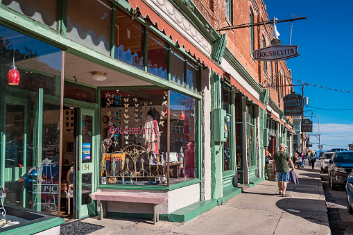 People walk past store facades in downtown Jerome Arizona USA on a sunny day