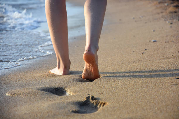 istock Woman walking on sandy beach 1065514056