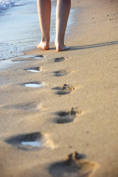 istock Woman walking on sandy beach 1065515480