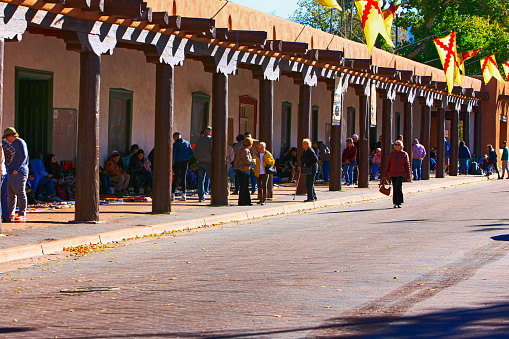 People at the famous Indian Market in the recess of the Palace of the Governors in the Plaza of Santa Fe, New Mexico USA