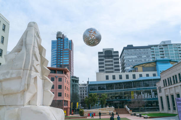 Silver steel globe comprising of and called Ferns shaped floating above Civic Square by artist Neil Dawson installed 1998.