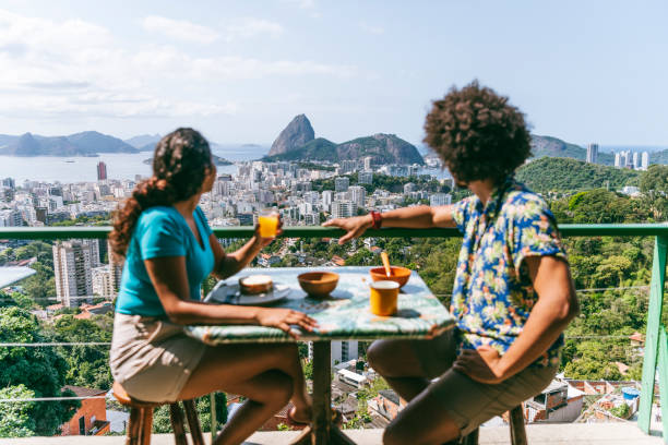 junges paar auf terrasse mit blick auf zuckerhut - brazil rio de janeiro city sugarloaf mountain stock-fotos und bilder