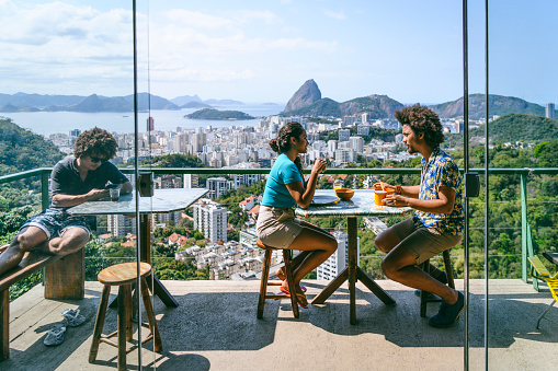 Man and woman on balcony, scenic view and city backdrop, on vacation