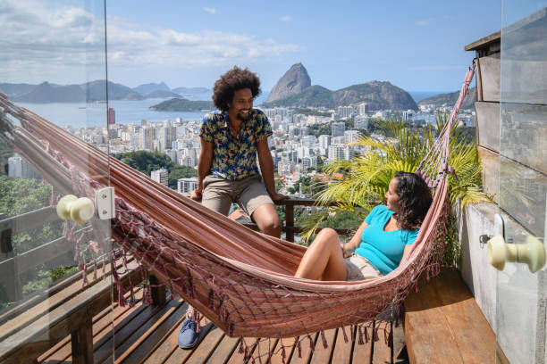 jovem casal na varanda com vista para rio no fundo - tropical destination - fotografias e filmes do acervo