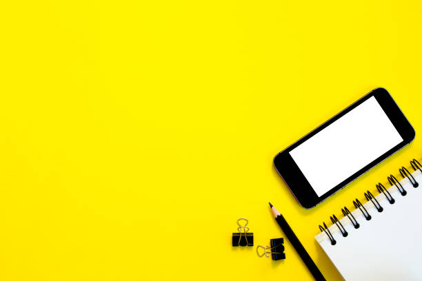 istock Telephone,notebook with pencil on yellow background. 1065533110