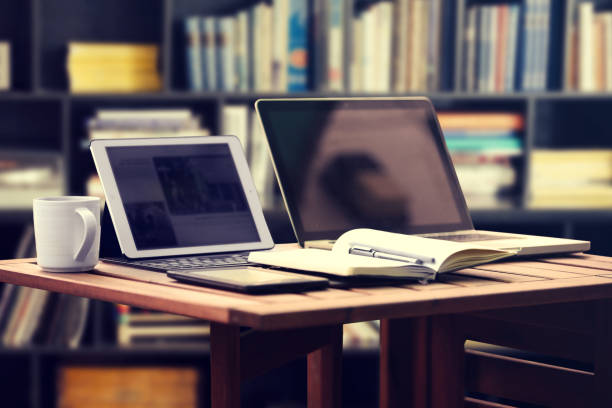 istock Laptop computers on working desk in library room with blurred bookshelf background, education concept 1065536672