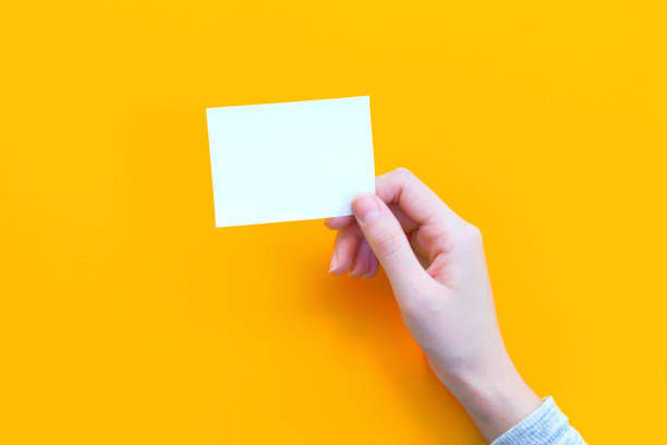 istock woman hand holding paper on orange background. 1065537214
