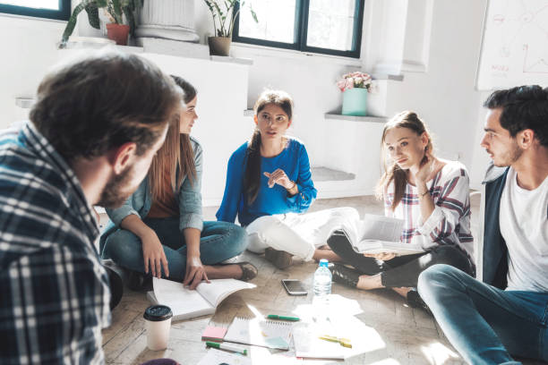 istock young people sitting on floor discussing 1065538732