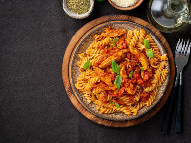 fusilli pasta with tomato sauce, chicken fillet with basil leaves on dark brown background, top view, copy space - pasta directly above fusilli food imagens e fotografias de stock