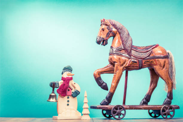 retrò antico cavallo di legno di natale su ruote giocattolo, vecchio pupazzo di neve con jingle bell e piccolo albero di capodanno. concetto di biglietto d'auguri per le vacanze. foto filtrata in stile instagram vintage - bell jingle christmas music foto e immagini stock