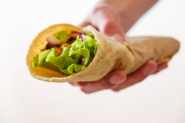 istock Mexican burrito in hand with chicken, pepper and beans 1065545418