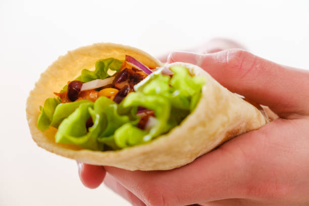 istock Mexican burrito in hand with chicken, pepper and beans 1065545454