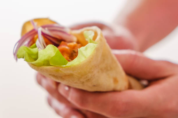 istock Mexican burrito in hand with chicken, pepper and beans 1065545490