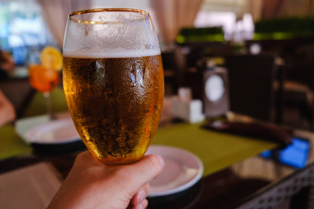 istock Beer in hand, cafe alcohol bar, restaurant cafe interior 1065545968