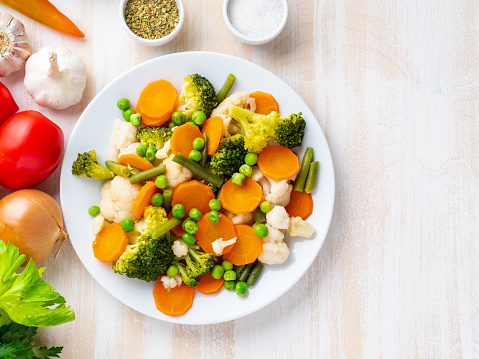 Mix of boiled vegetables, steam vegetables for dietary low-calorie diet. Broccoli, carrots, cauliflower, top view, copy space.