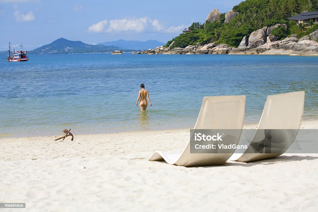 Lettino e ragazza su una spiaggia di mare - Foto stock royalty-free di Nudista